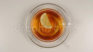 顶部视图：<strong>柠檬片</strong>在红茶中游泳，在一个玻璃茶杯和一个<strong>盘子</strong>